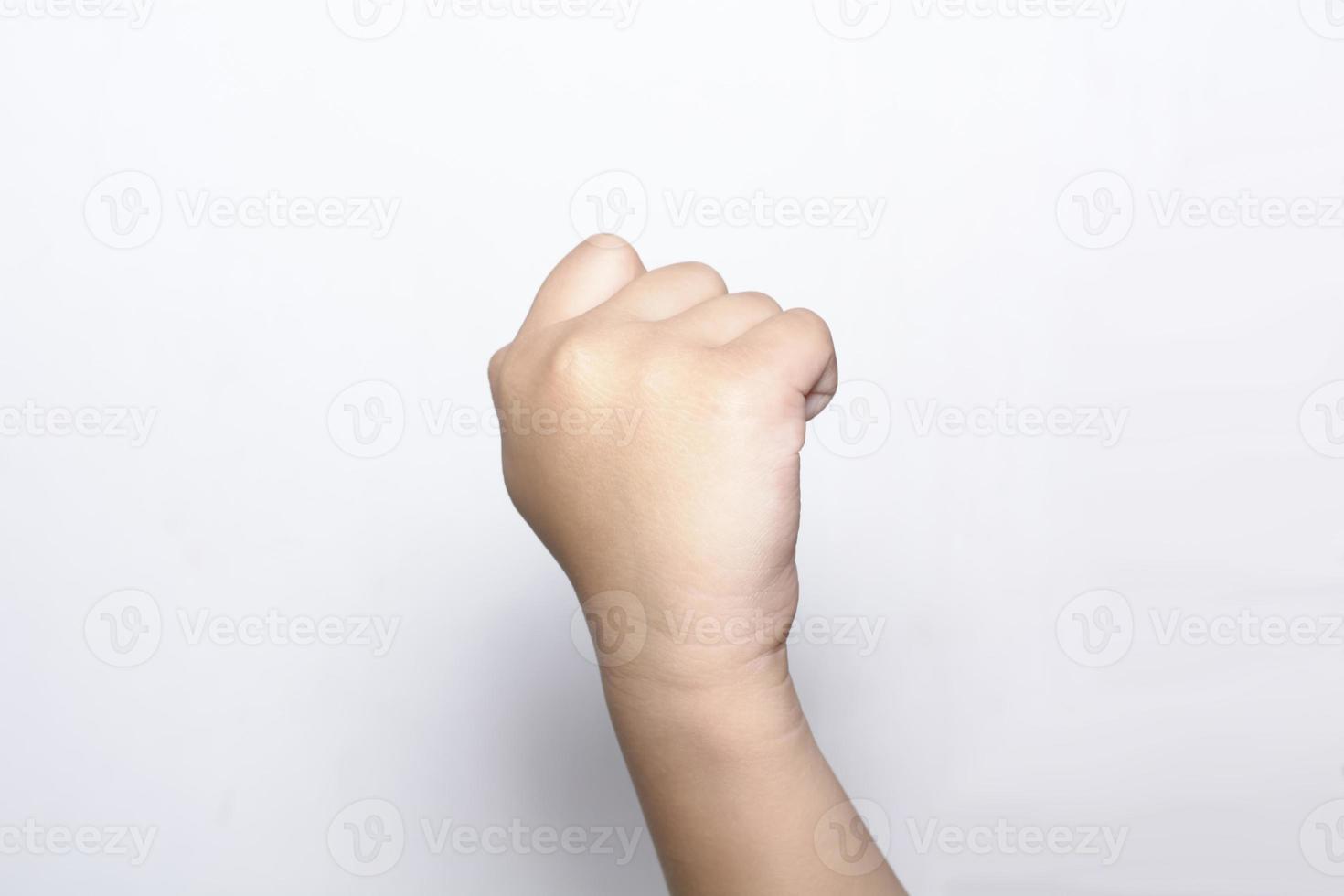 fille levant la main du poing sur fond blanc photo