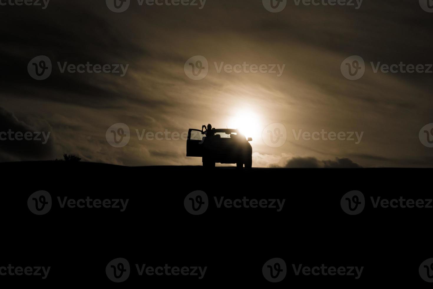 coucher de soleil derrière une voiture photo