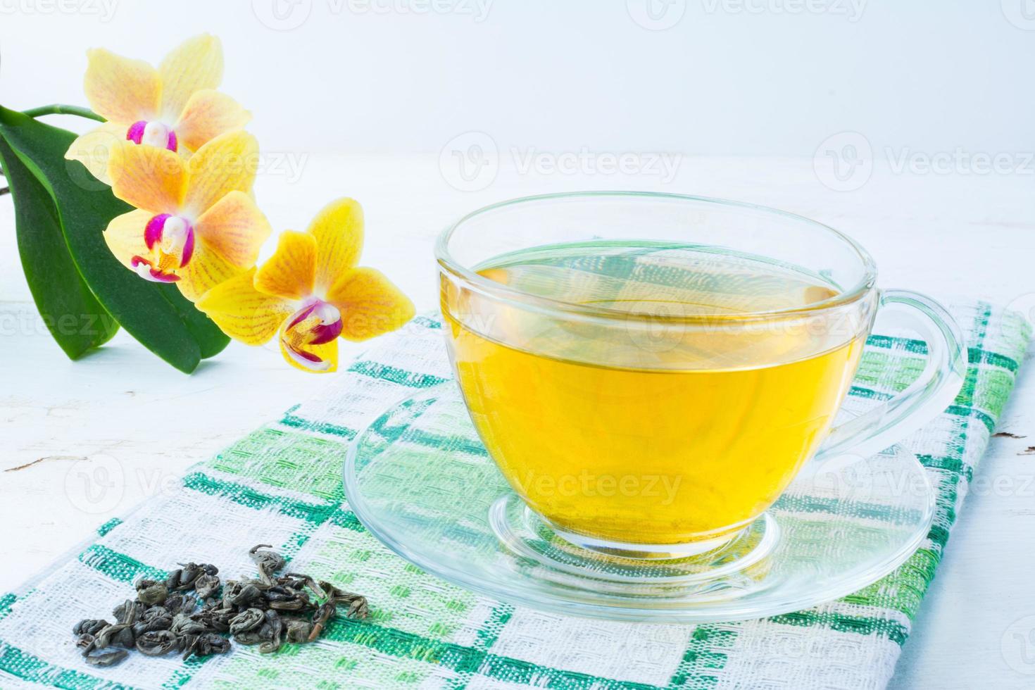 tasse de thé sur une serviette à carreaux verte photo
