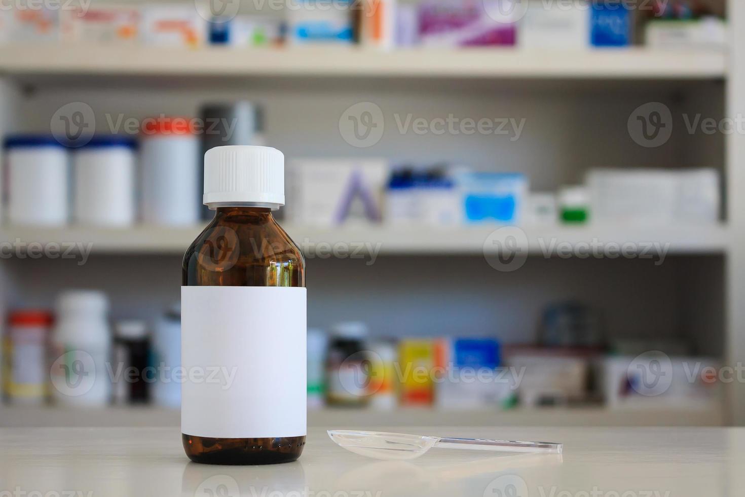 étiquette blanche vierge de flacon de médicament avec des étagères floues de médicament dans l'arrière-plan de la pharmacie de la pharmacie photo