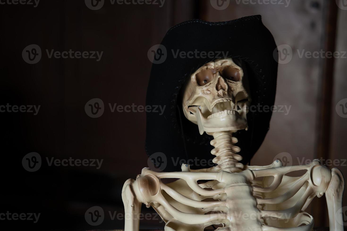 une maquette d'un squelette dans un chapeau sur fond sombre avec une place pour une inscription photo
