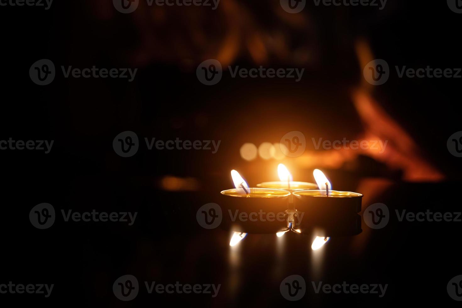 trois bougies sur fond noir avec une flamme de cheminée. photo