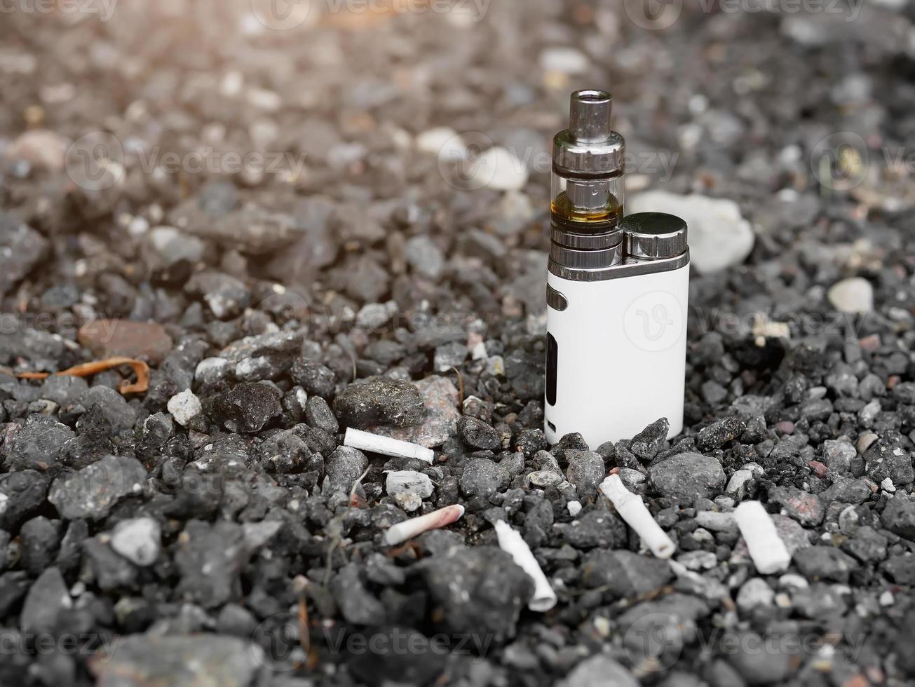 générateur de vapeur électronique sur fond de mégots de cigarettes photo