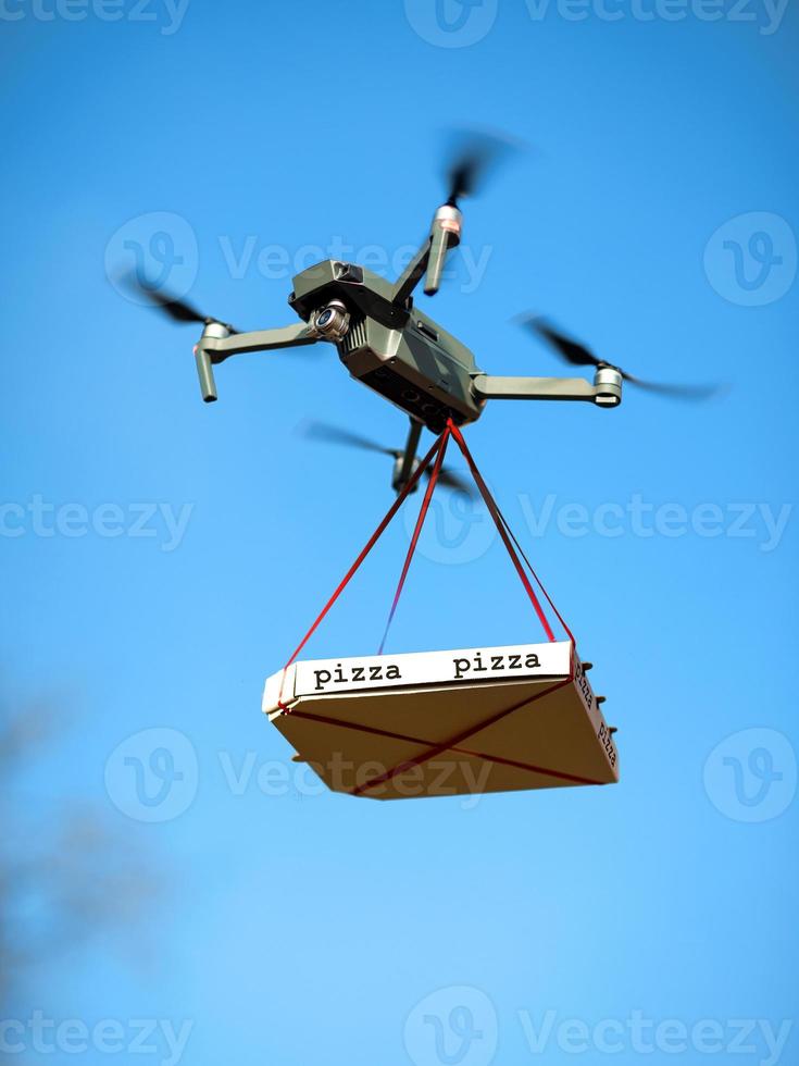 drone de livraison de pizza. la pizza est liée au quad photo