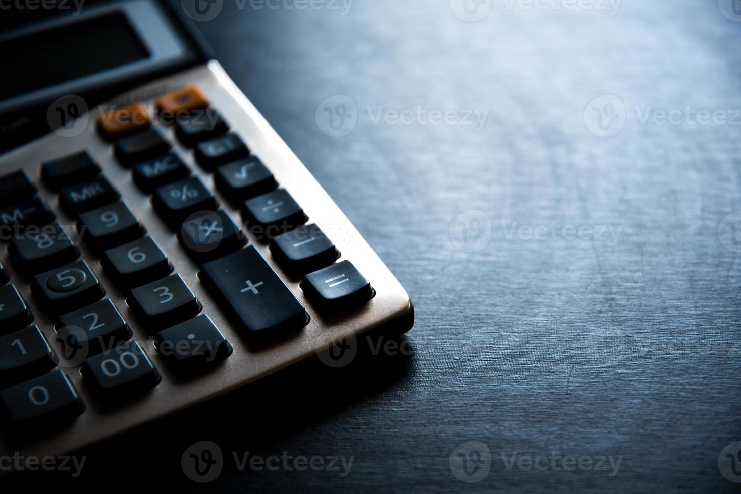 calculatrice sur table en bois et fond sombre photo
