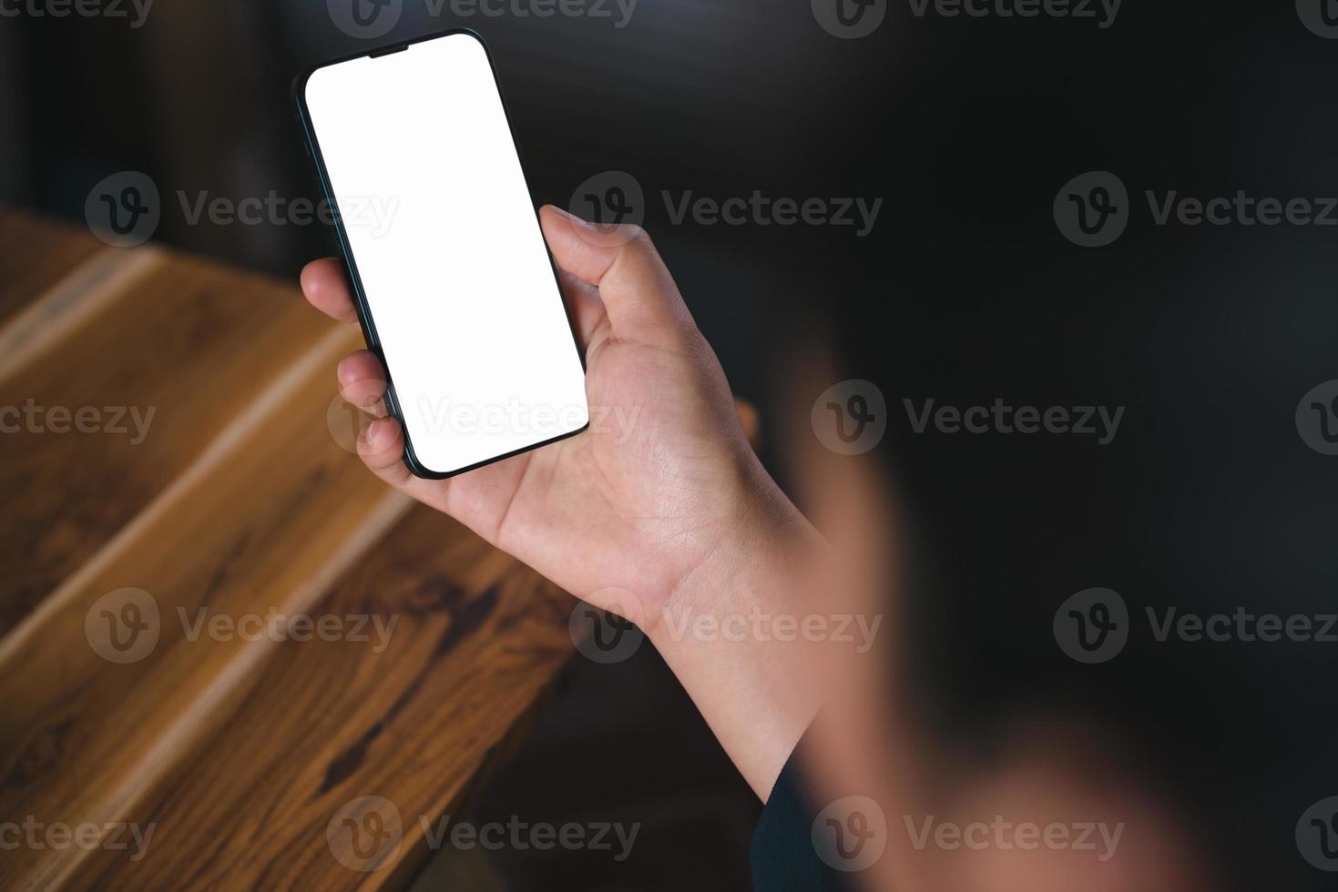 l'image maquette des mains de la femme utilise un smartphone avec un écran blanc vide pour un espace copie sur le bureau. concept de connexion de communication internet portable et technologie de téléphone portable numérique. photo