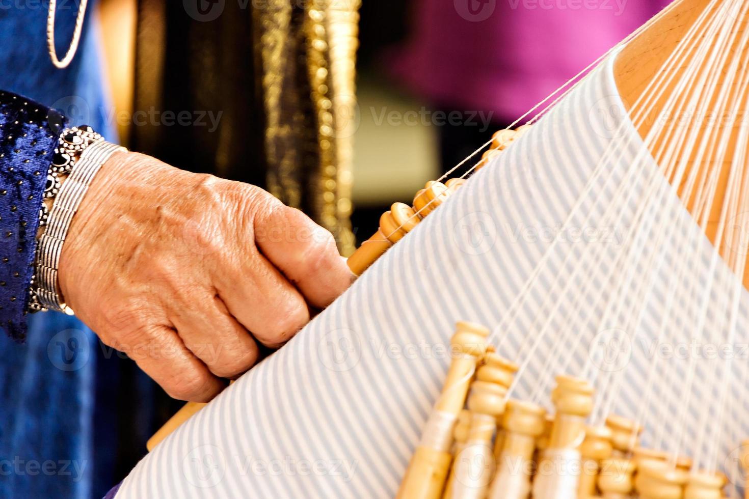 artisane travaillant avec de la dentelle aux fuseaux dans un marché artisanal. photo