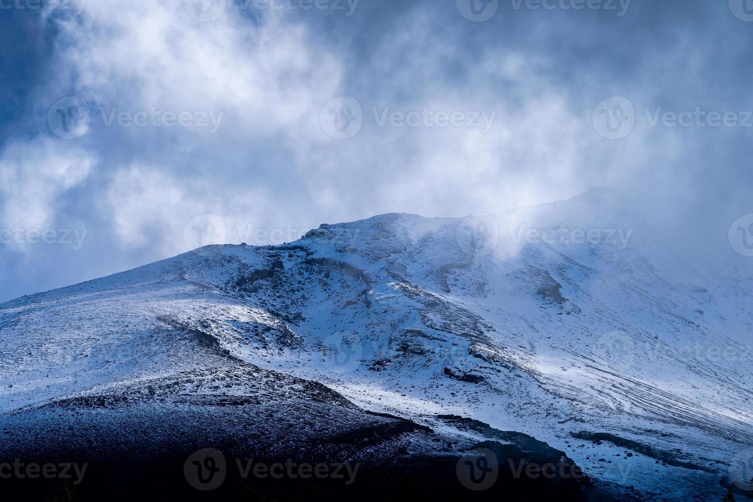 gros plan sur le sommet de la montagne fuji avec couverture de neige et vent au sommet avec pourrait au japon. photo