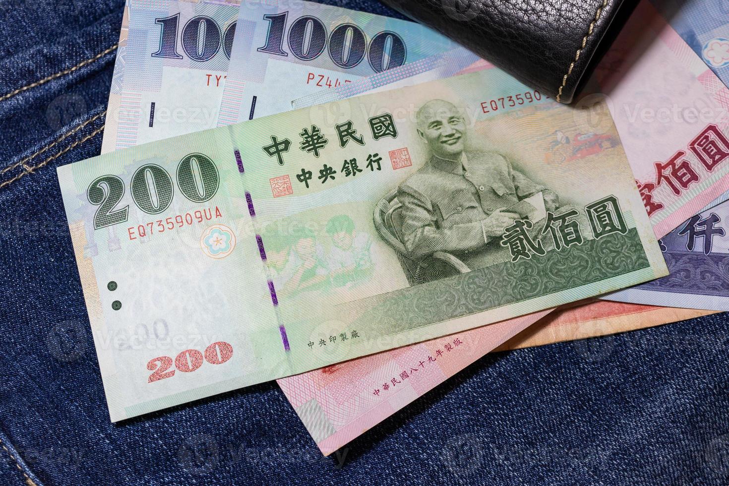 argent taïwanais, billet de banque de taïwan, dollar de taïwan sur fond de jean. photo
