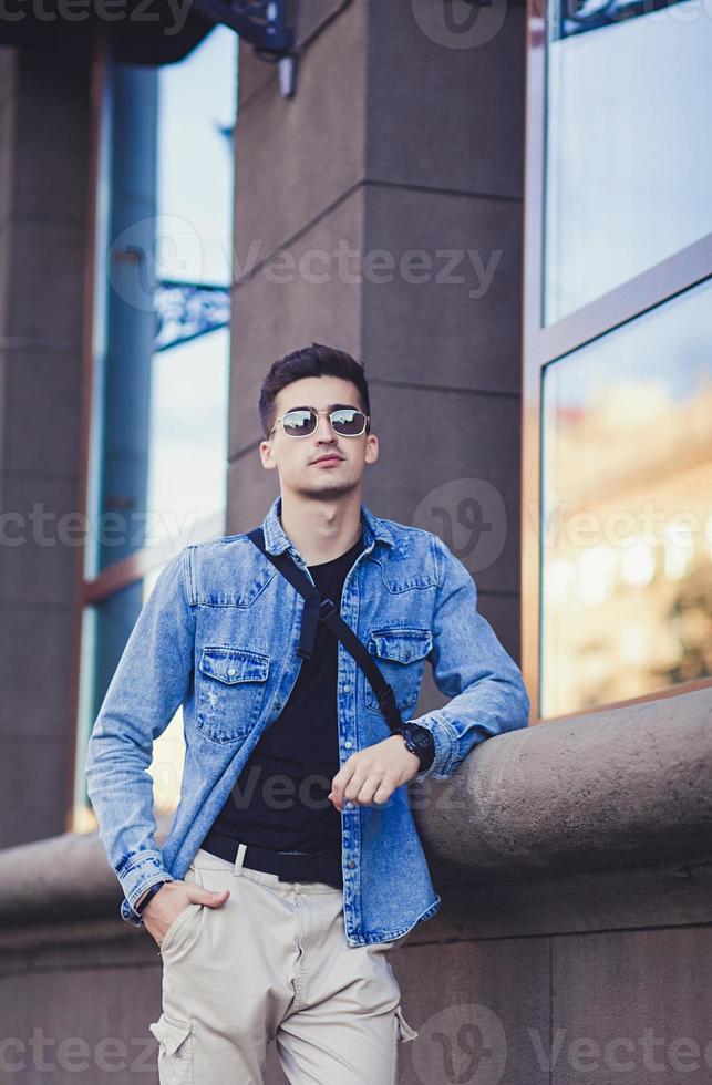 beau jeune homme à lunettes de soleil photo