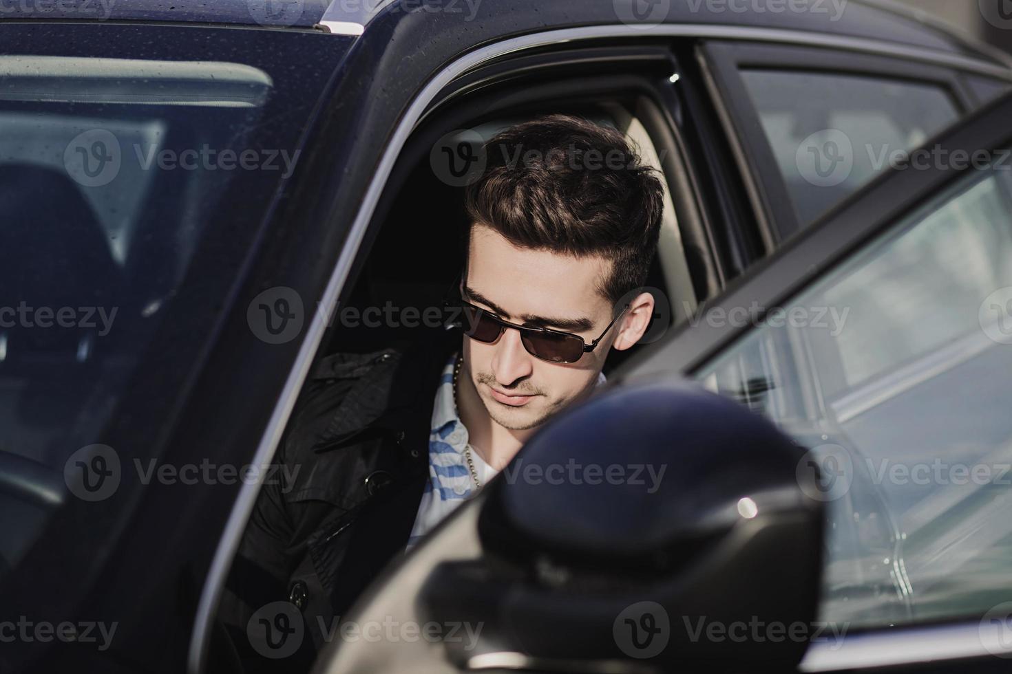 homme portant des lunettes au volant d'une voiture photo