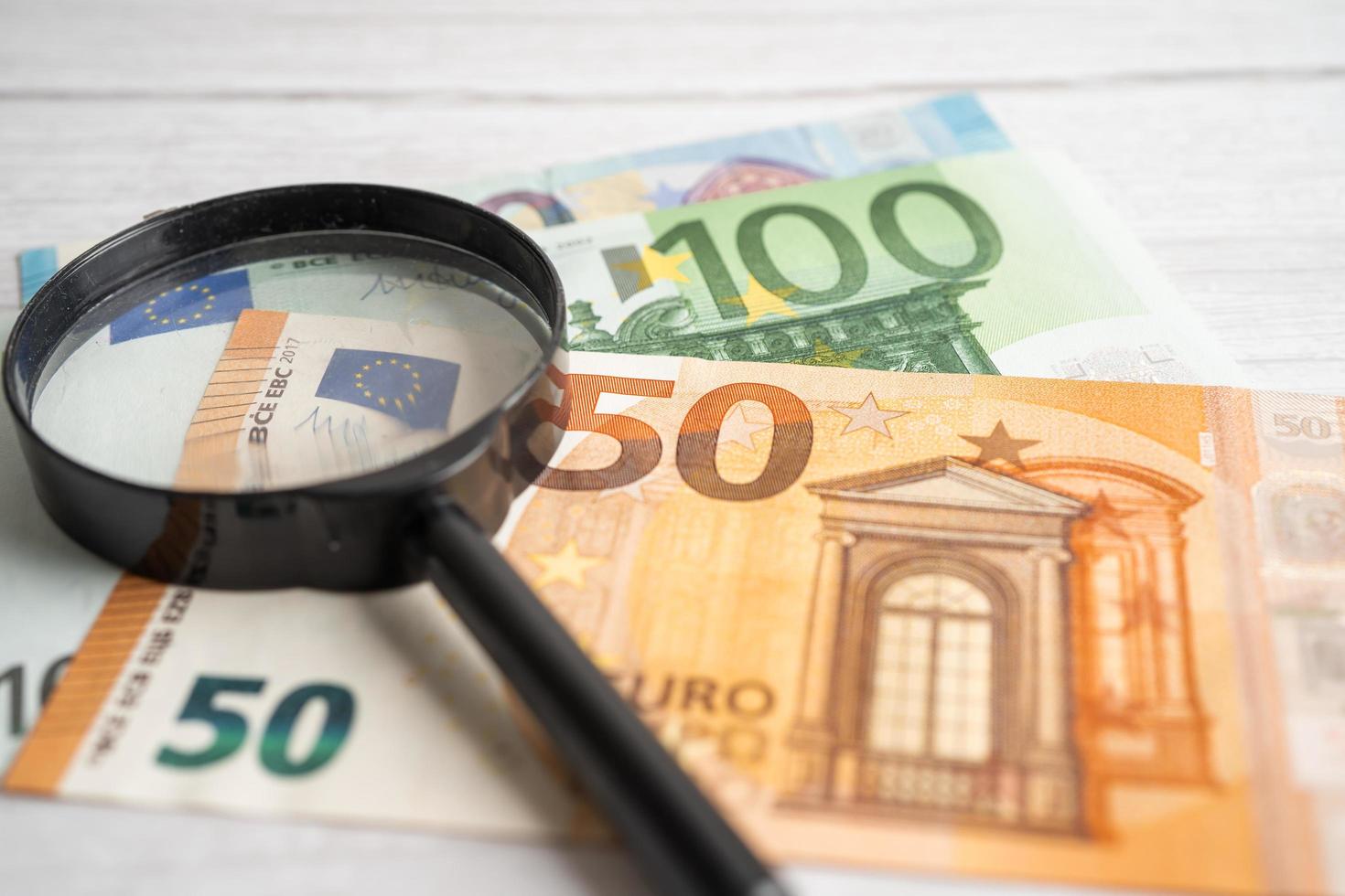 loupe avec fond de billets de banque de l'ue, compte bancaire, économie de données de recherche analytique d'investissement, commerce, concept d'entreprise. photo