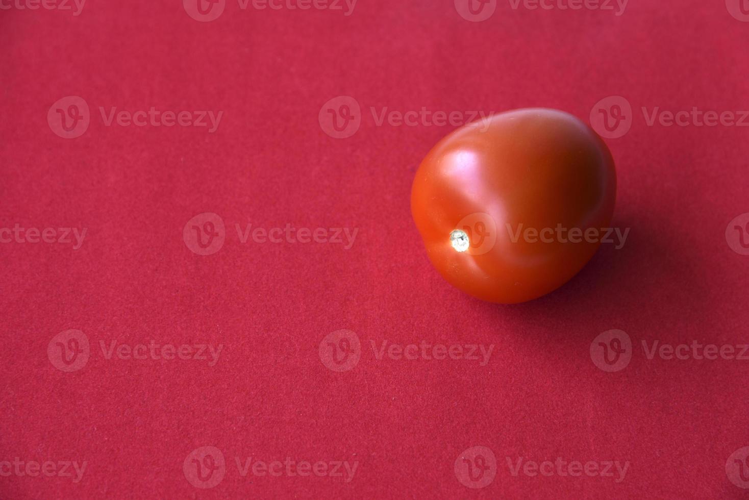 tomate juteuse sur fond rouge photo