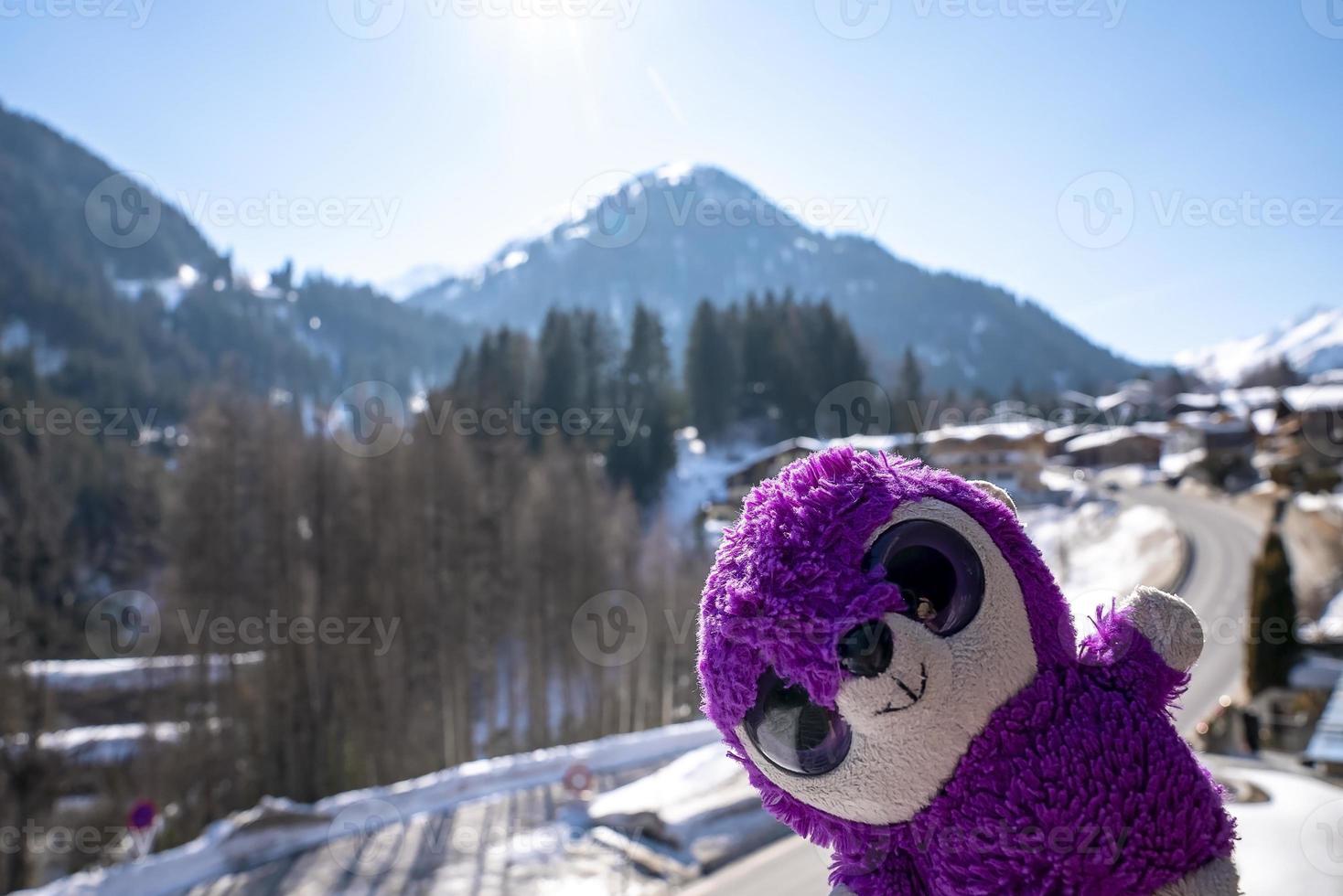peluche violette préférée contre la forêt et la montagne aux beaux jours de l'hiver photo