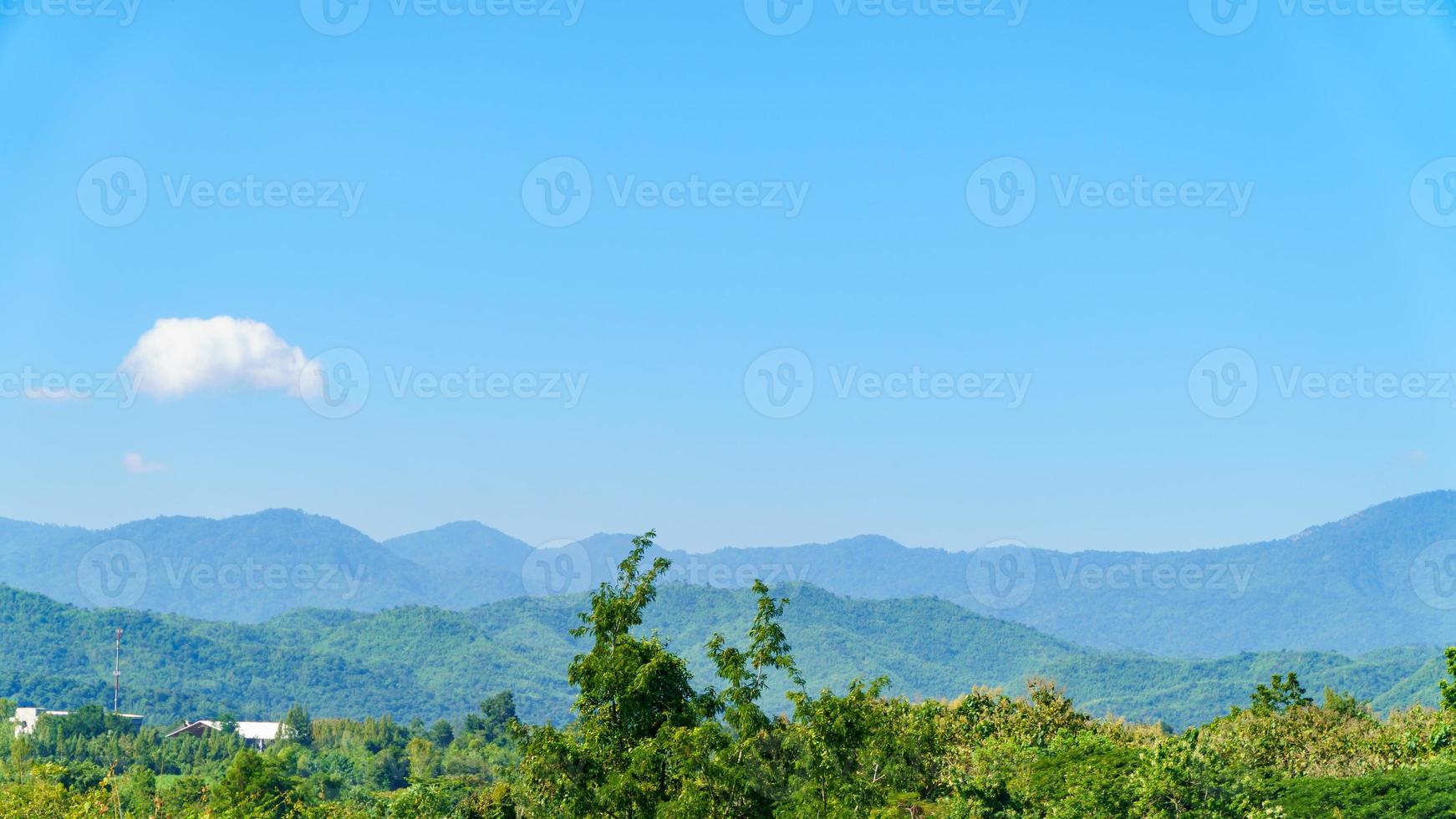 les montagnes sont remplies de verdure contre le ciel bleu. photo