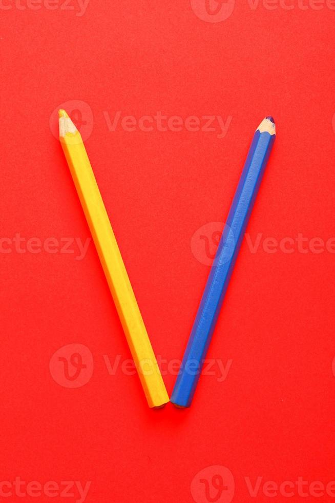 crayons jaunes et bleus sur fond rouge vif. photo