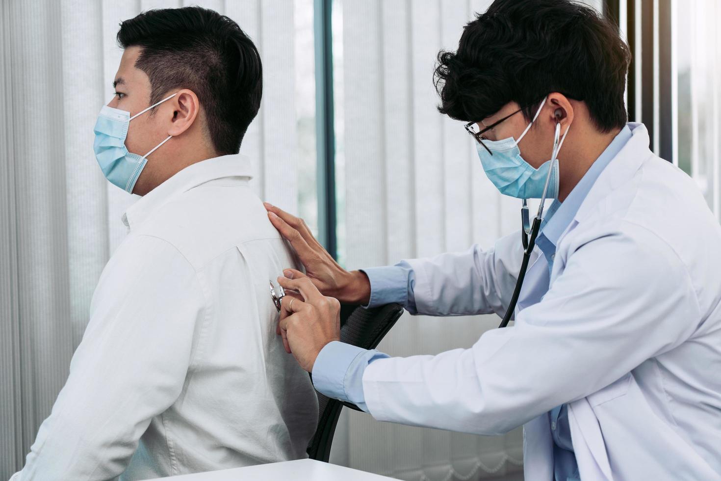 un médecin asiatique utilise un stéthoscope pour écouter le rythme cardiaque du patient. photo