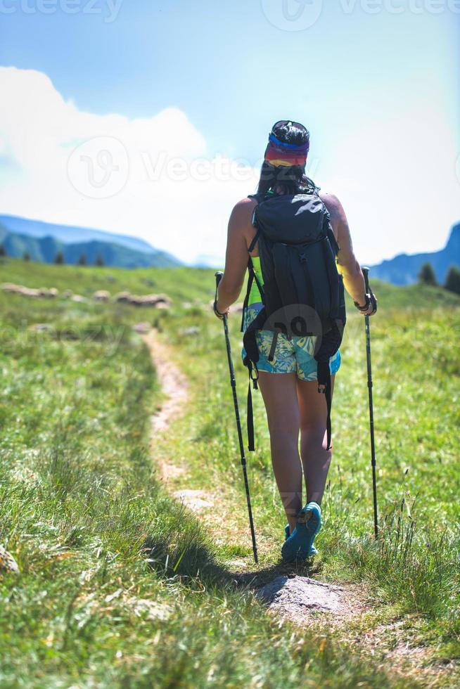 fille descend le chemin de la colline en été photo