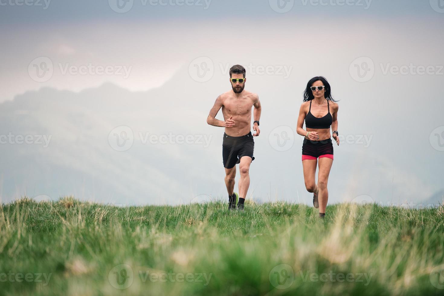 l'homme et la femme sportifs courent chaud en été sur les prés des collines photo