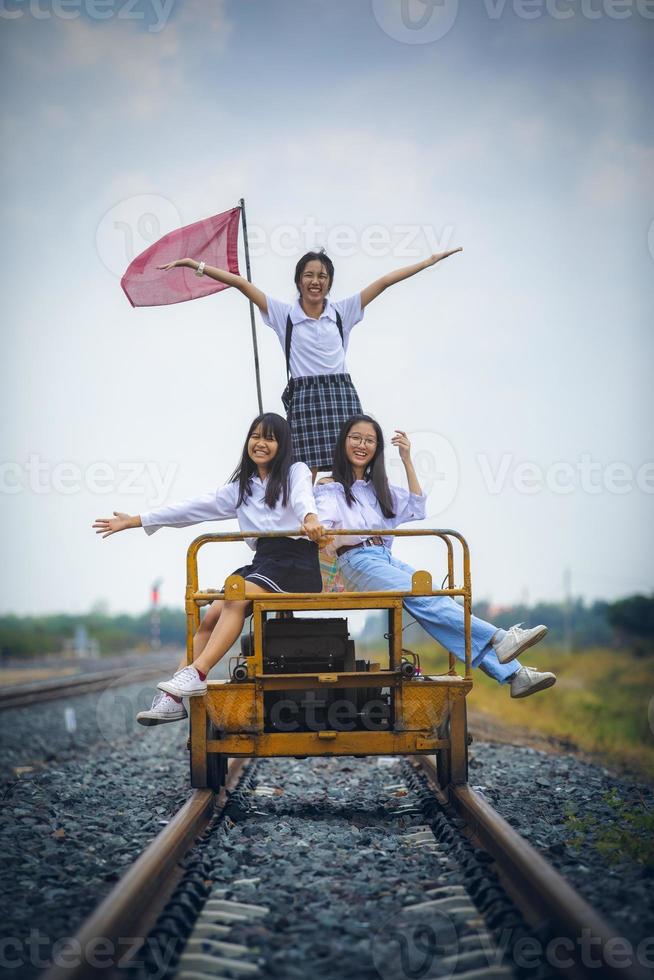 groupe d'adolescents asiatiques souriant avec bonheur face à la voie ferrée photo