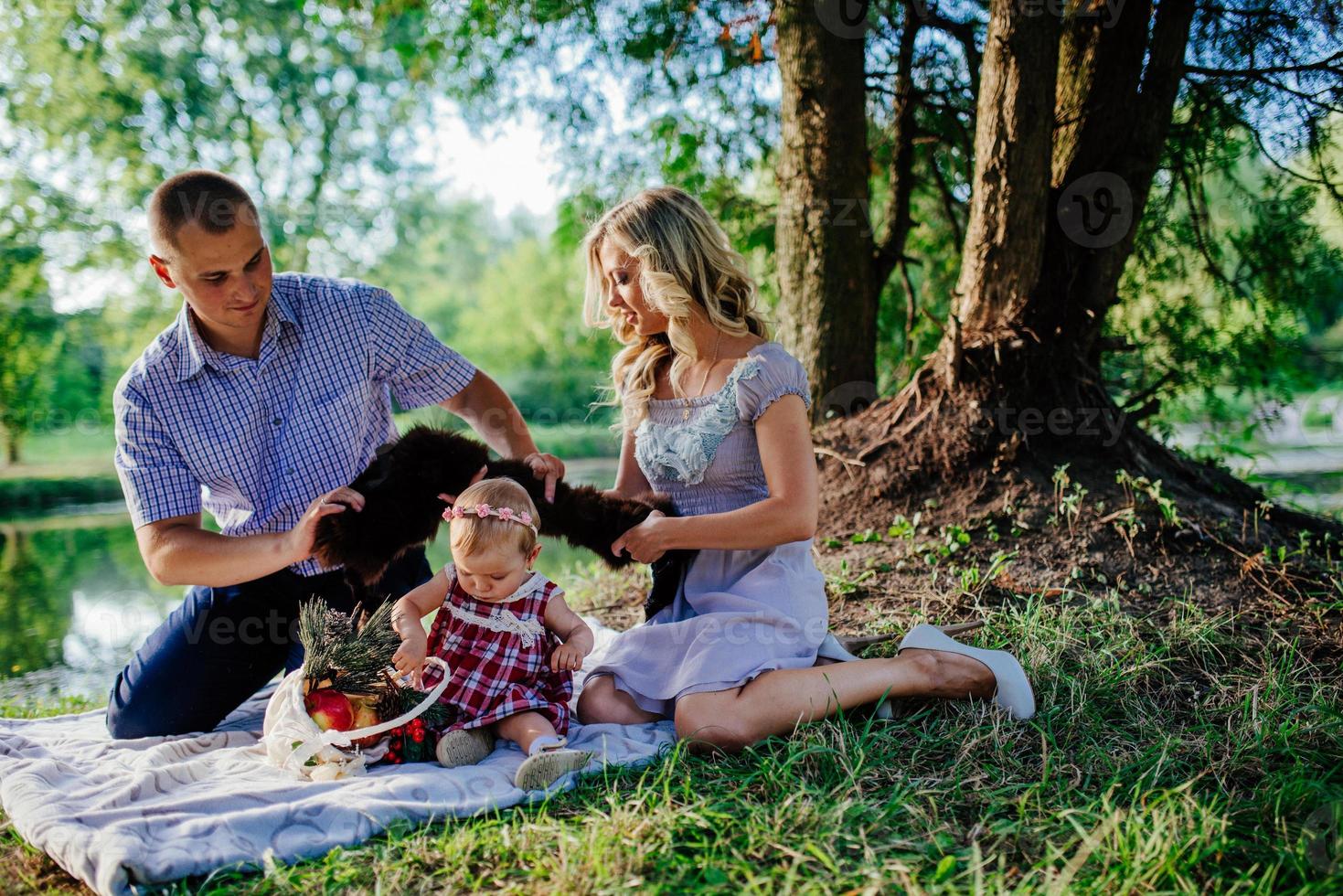 une famille heureuse se promène dans le parc d'été verdoyant photo