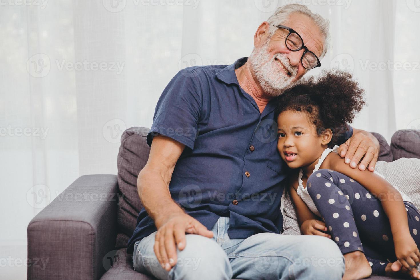 grand-père embrasse l'amour de la petite fille nièce dans une maison familiale chaleureuse. photo