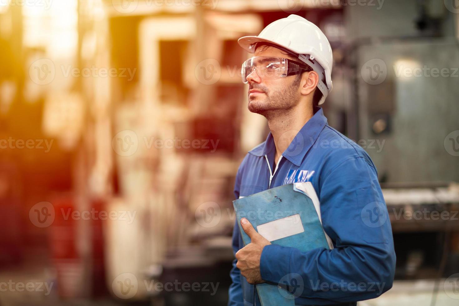 portrait d'un livre de manuel de service de machine d'éducation d'ingénieur intelligent travailleur heureux debout fièrement dans l'arrière-plan de l'industrie lourde. photo