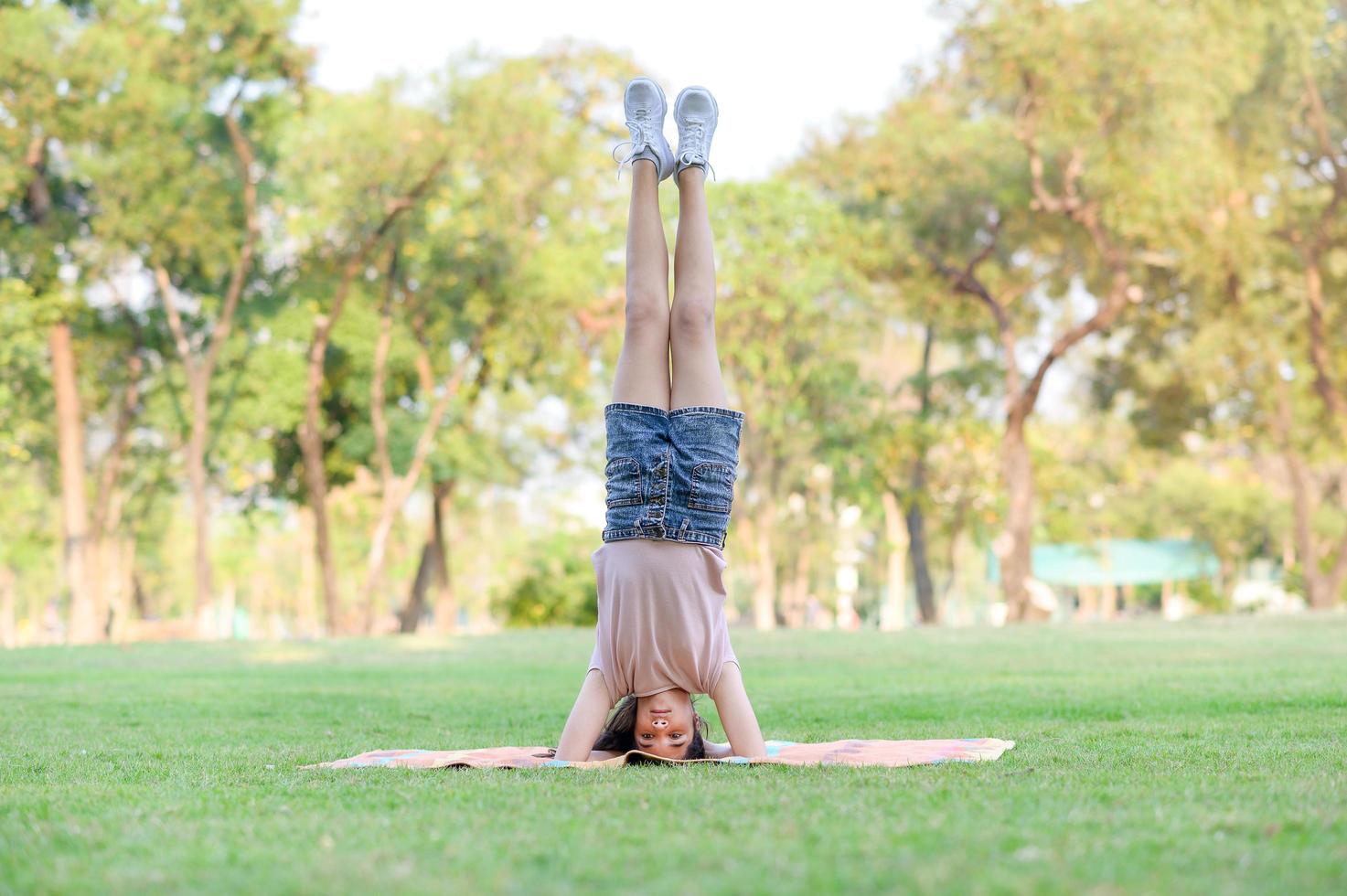 la moitié des filles thaïlandaises et européennes exerçant en gymnastique dans le cadre de leur apprentissage en dehors de l'école dans le parc photo