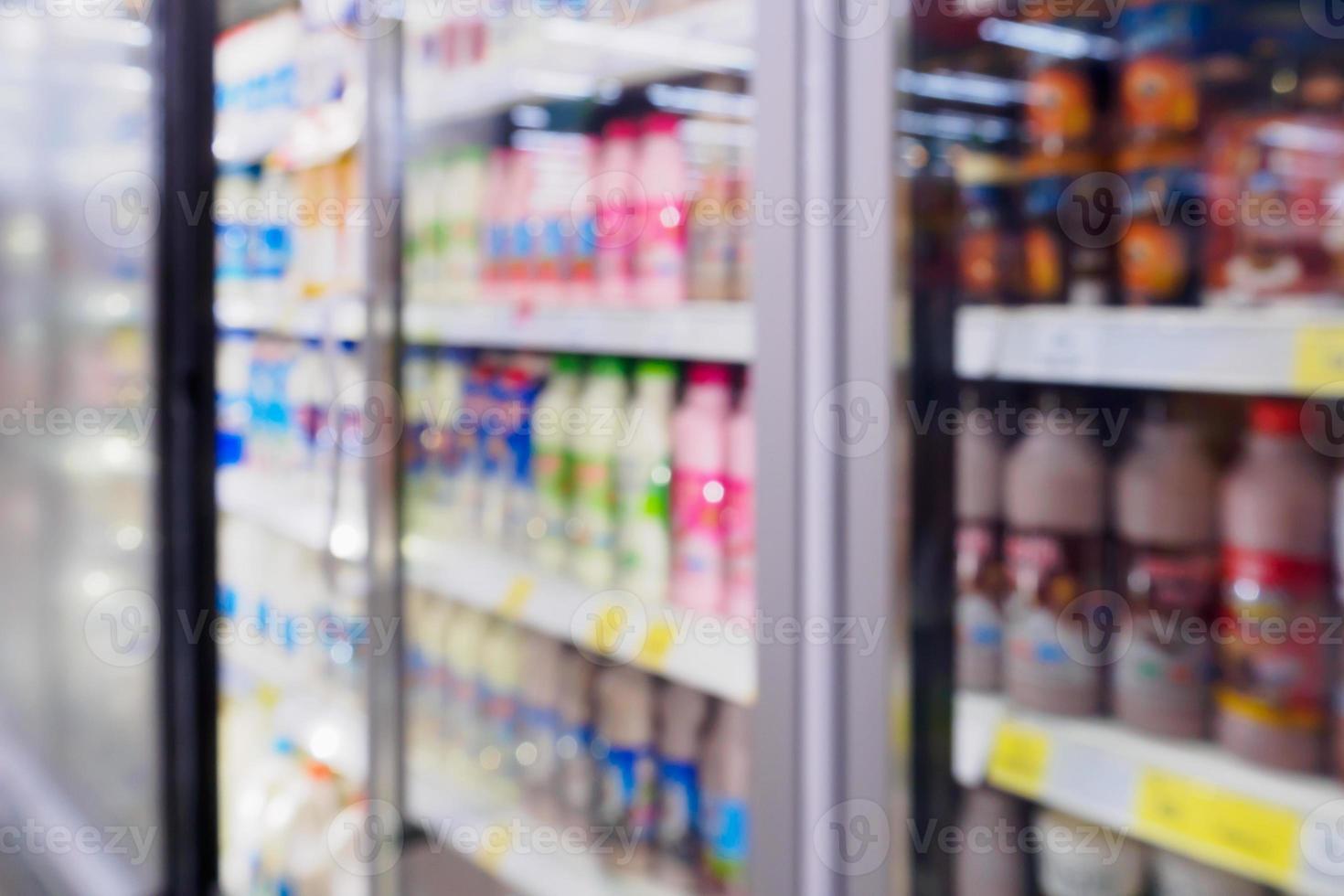 brouiller les bouteilles de lait de produits laitiers sur l'étagère du réfrigérateur dans un supermarché photo