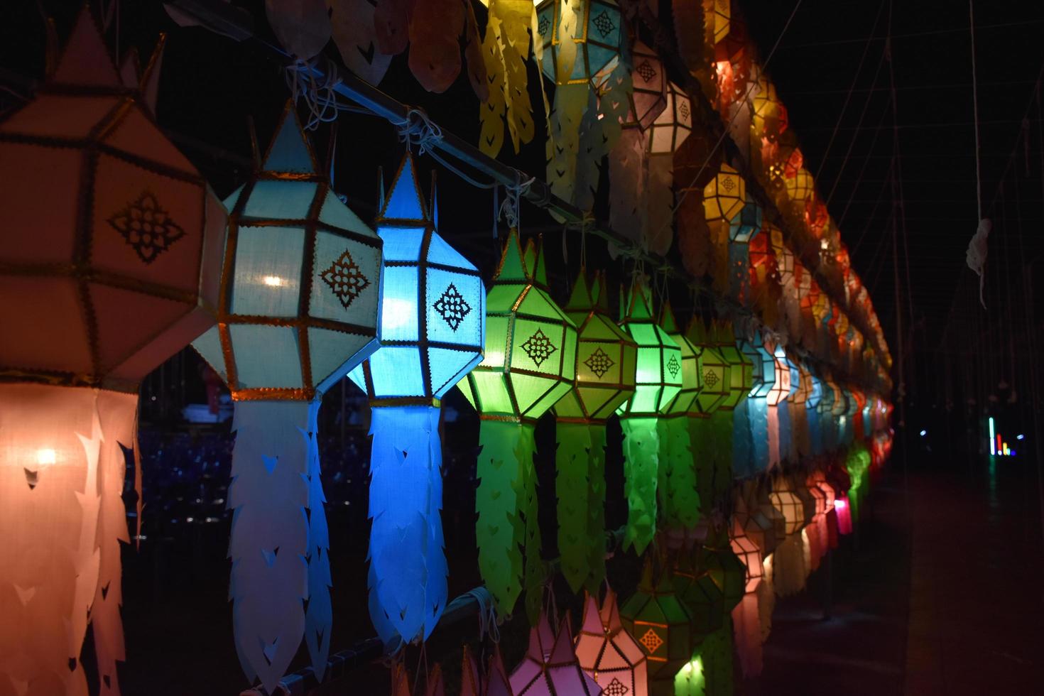 des lanternes en papier magnifiquement formées et colorées sont accrochées devant une pagode pour adorer le seigneur bouddha dans un temple du nord de la thaïlande. photo