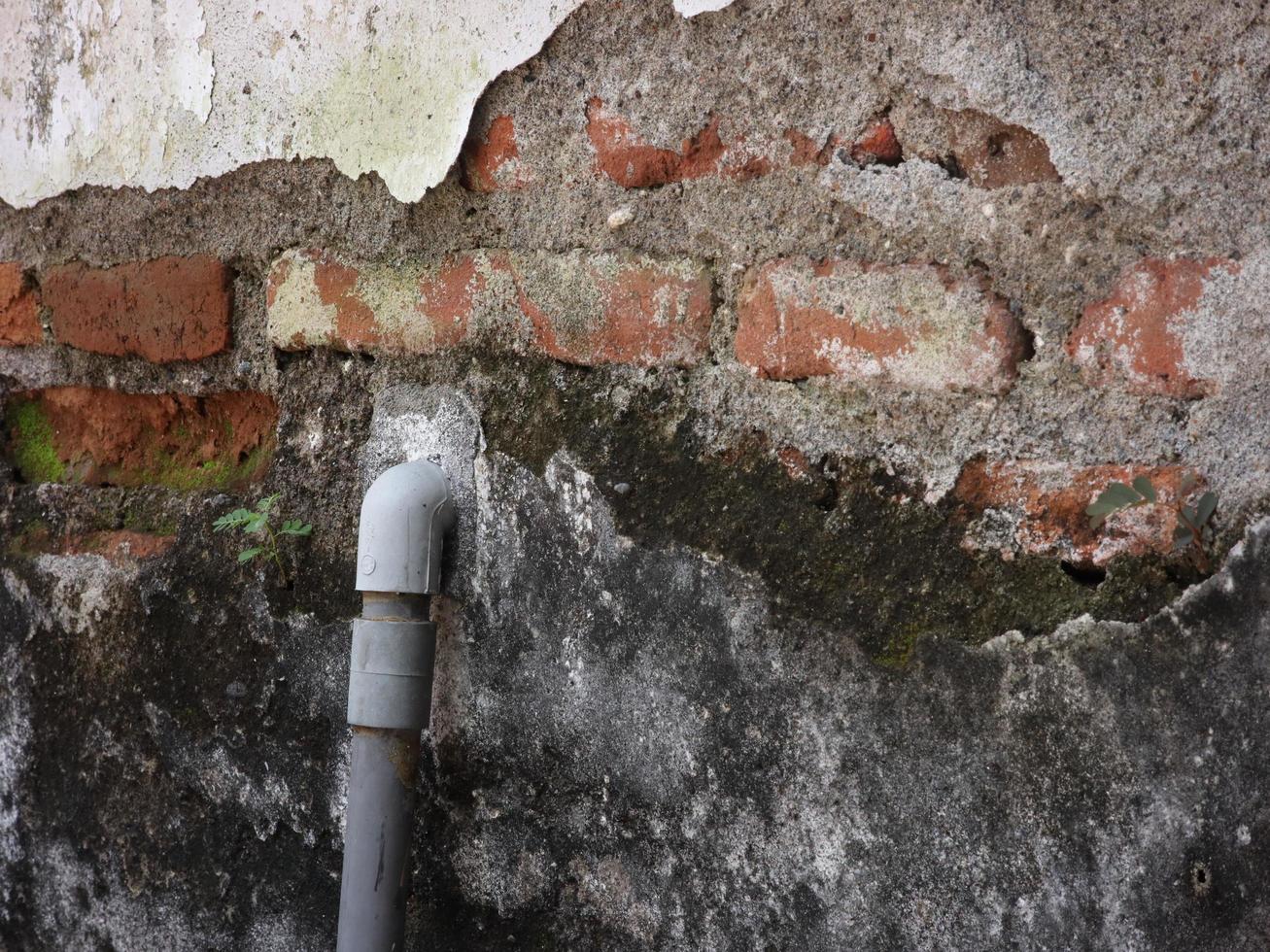 le mur de la maison est endommagé jusqu'à ce que vous puissiez voir la conduite d'eau photo