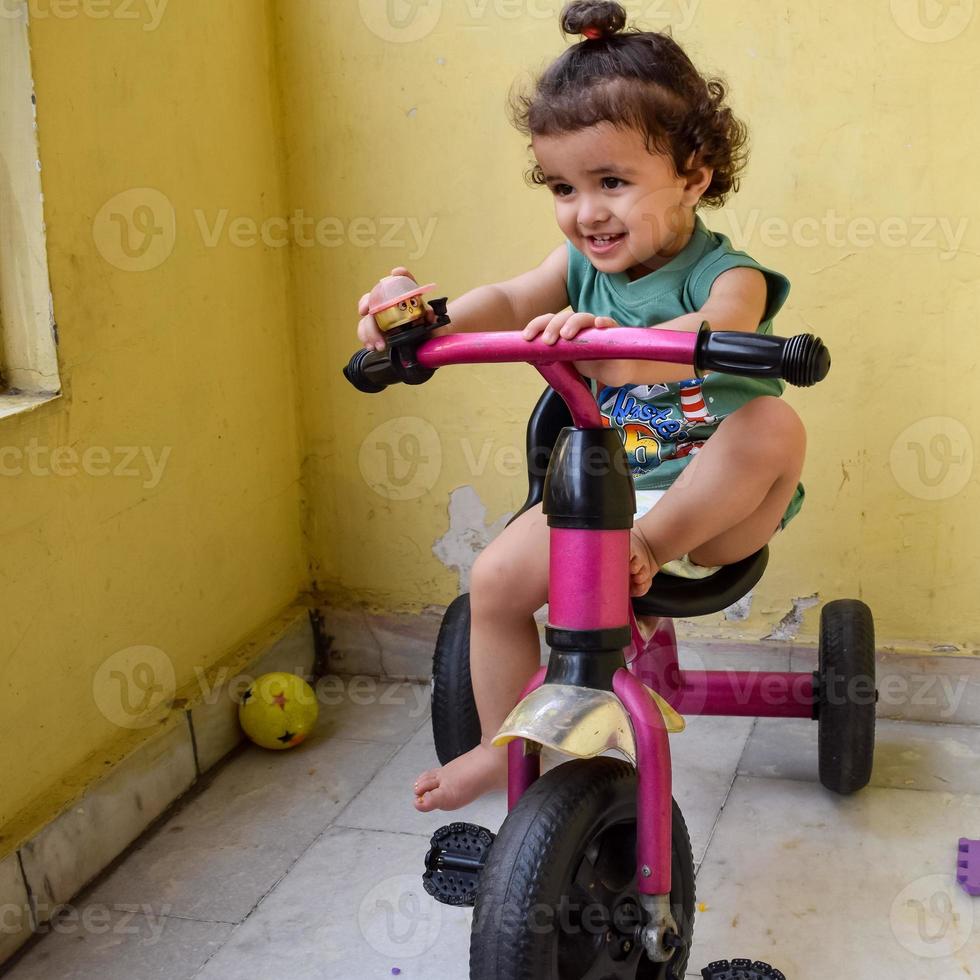 mignon petit garçon shivaay cycle de conduite sur le balcon de la maison pendant l'été, doux petit garçon photoshoot pendant la lumière du jour, petit garçon aime faire du vélo à la maison pendant la séance photo