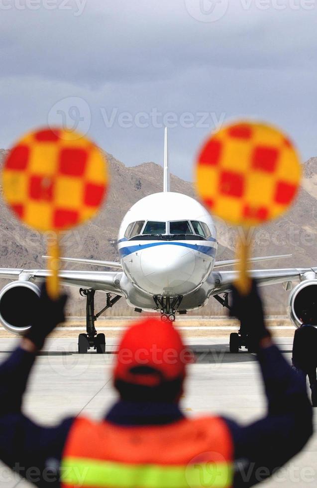 aéroport - un personnel de l'aéroport dirige un aéronef en position à l'aéroport photo