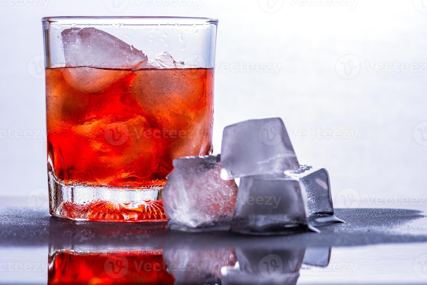 verre de whisky et de glace sur une table en verre photo