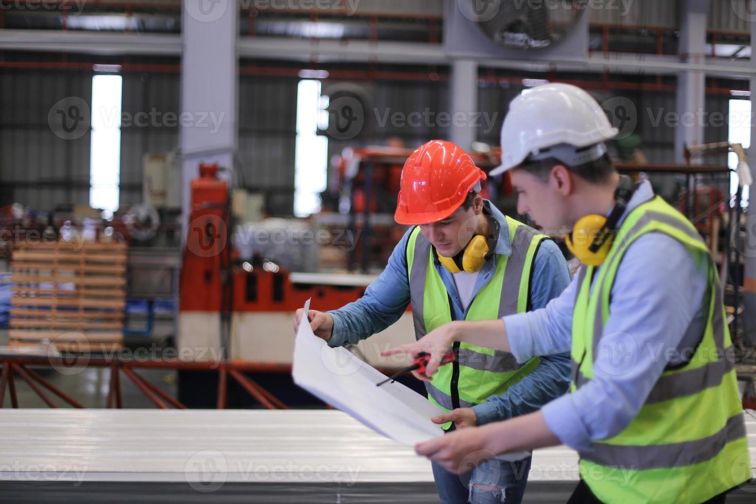 le contremaître ou le travailleur de l'industrie travaille sur le site de l'usine pour vérifier la machine ou les produits sur le site. ingénieur ou technicien vérifiant le matériel ou la machine sur l'usine. industriel et usine. photo