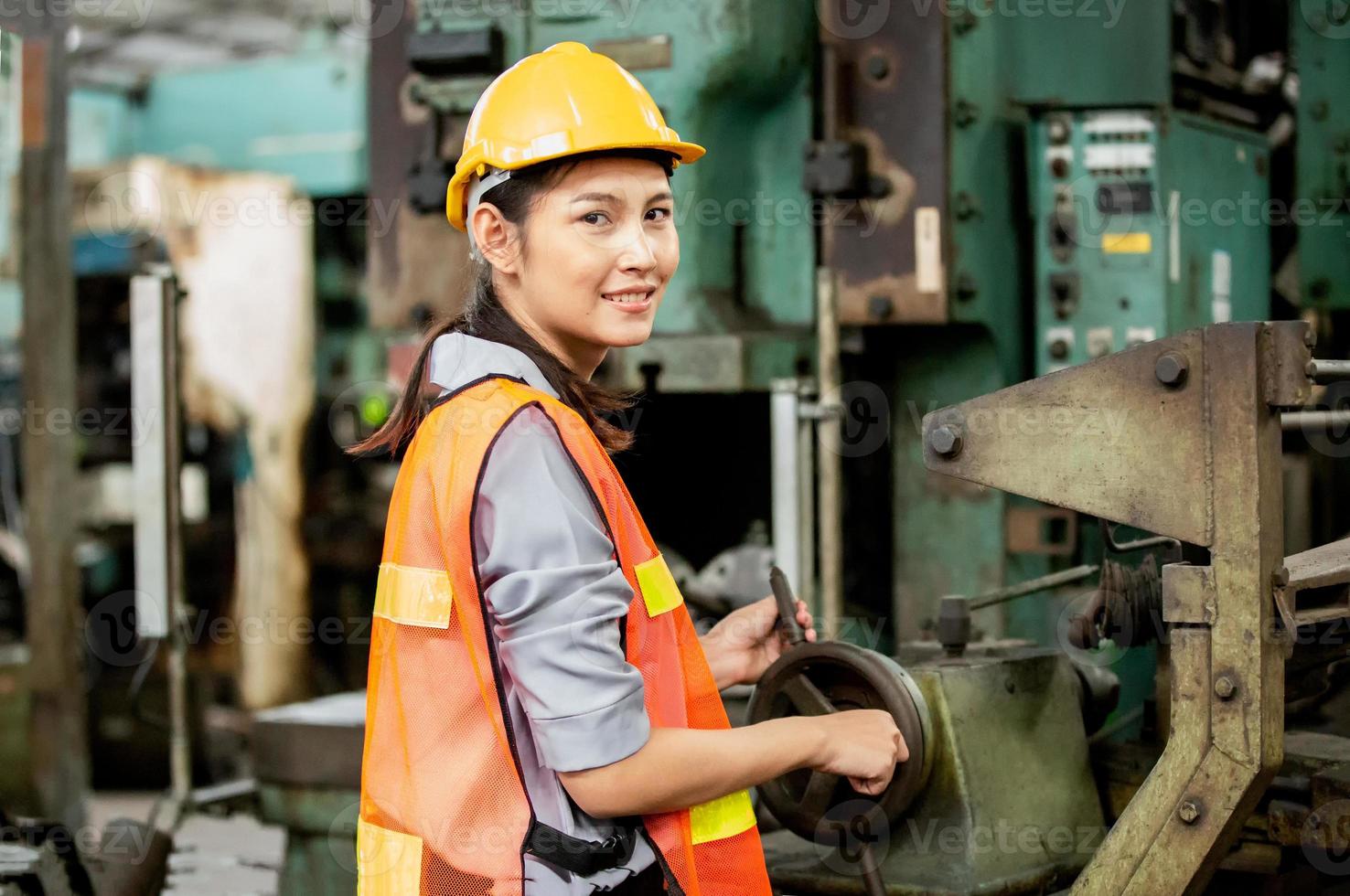 une travailleuse travaille sur le site de l'usine vérifie la machine dans la gamme de produits ou les produits sur le site. ingénieur ou technicien vérifiant le matériel ou la machine sur l'usine. industriel et usine. photo