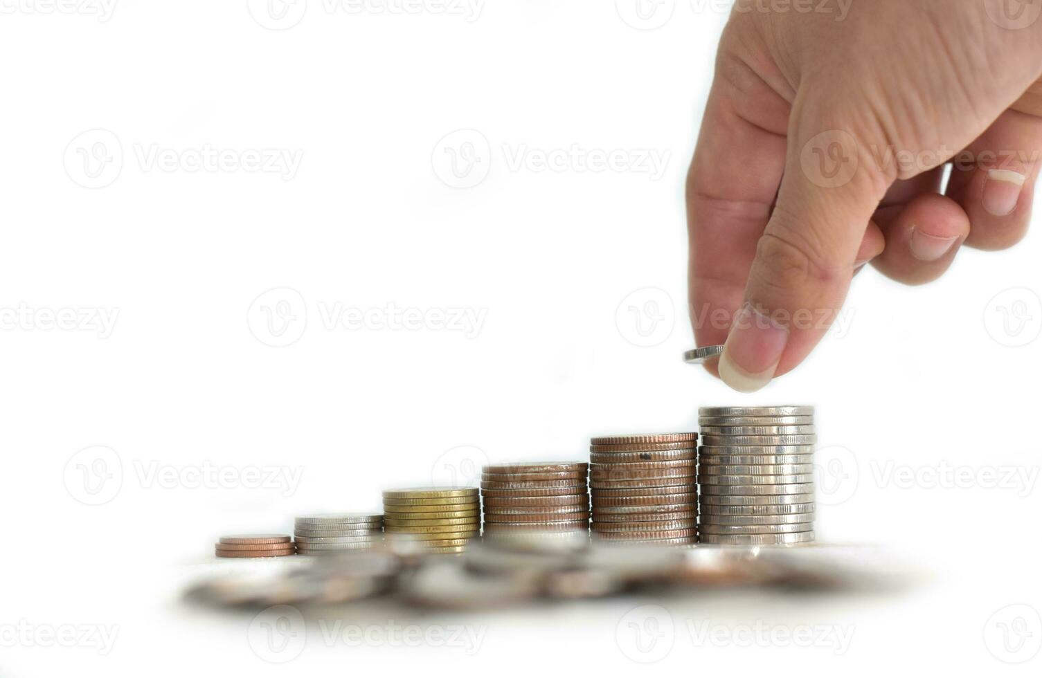 la main de l'homme a mis des pièces d'argent sur une pile de pièces. concept de croissance financière et commerciale photo