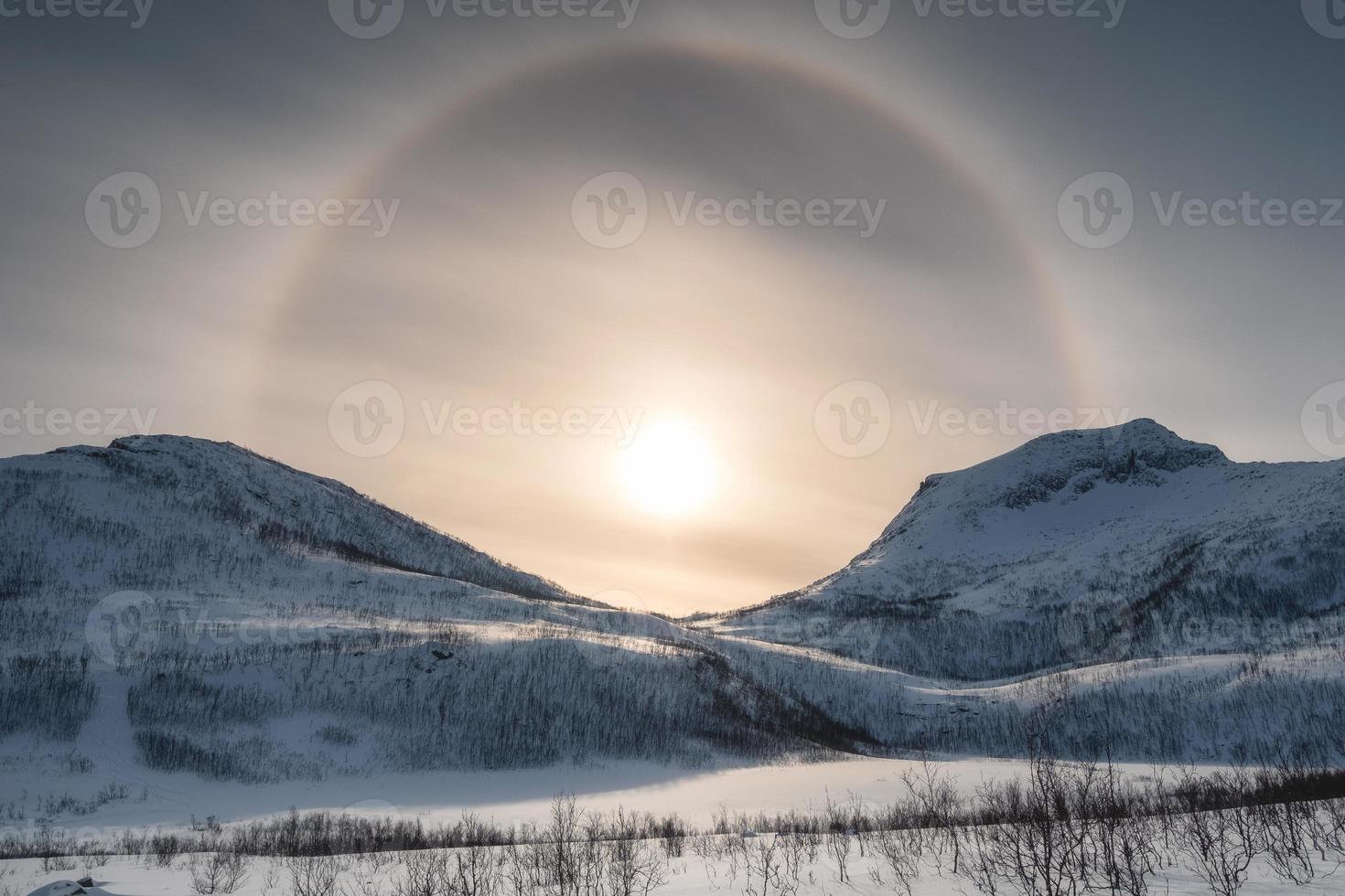 chaîne de montagnes de neige avec halo de soleil en hiver photo