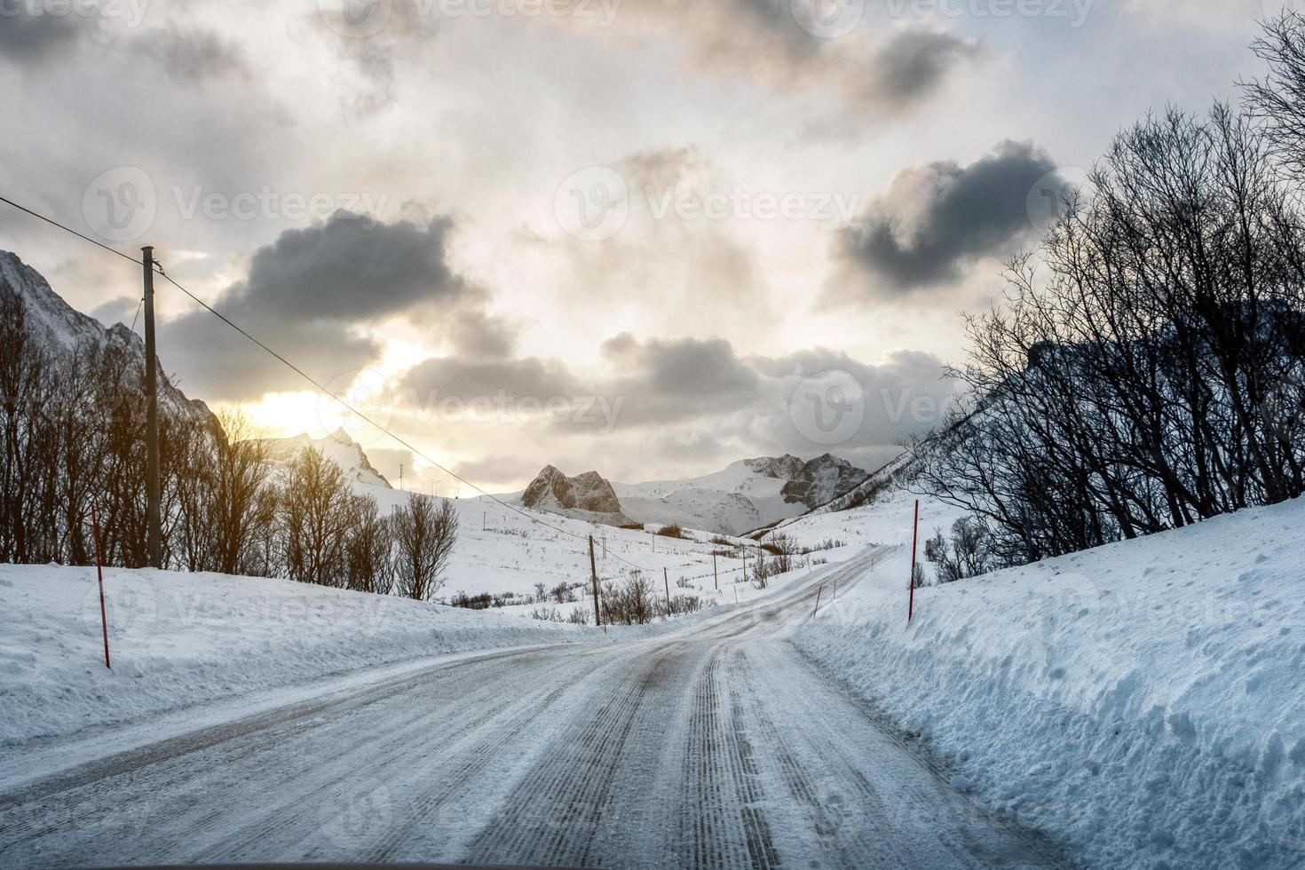 route de neige sale avec la lumière du soleil sur les montagnes photo