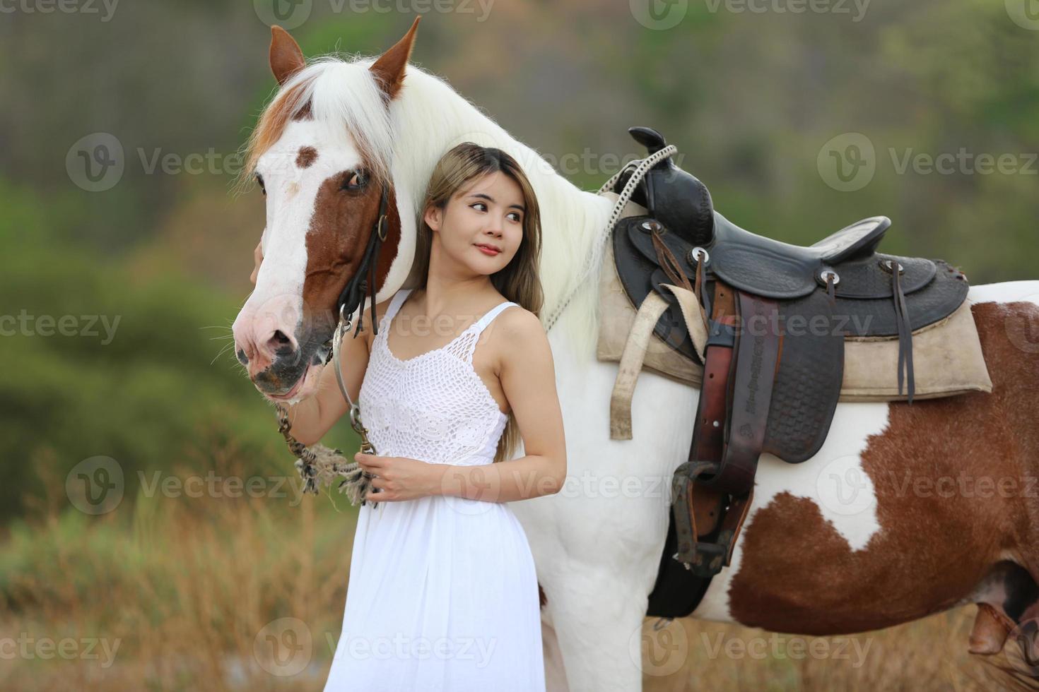 jeune femme avec son cheval dans la lumière du coucher du soleil du soir. photographie en plein air avec une fille mannequin. mode de vie photo