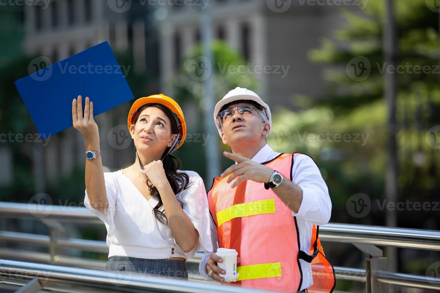 l'ingénieur et la femme d'affaires vérifient le presse-papiers sur le chantier de construction. le concept d'ingénierie, de construction, de vie urbaine et d'avenir. photo