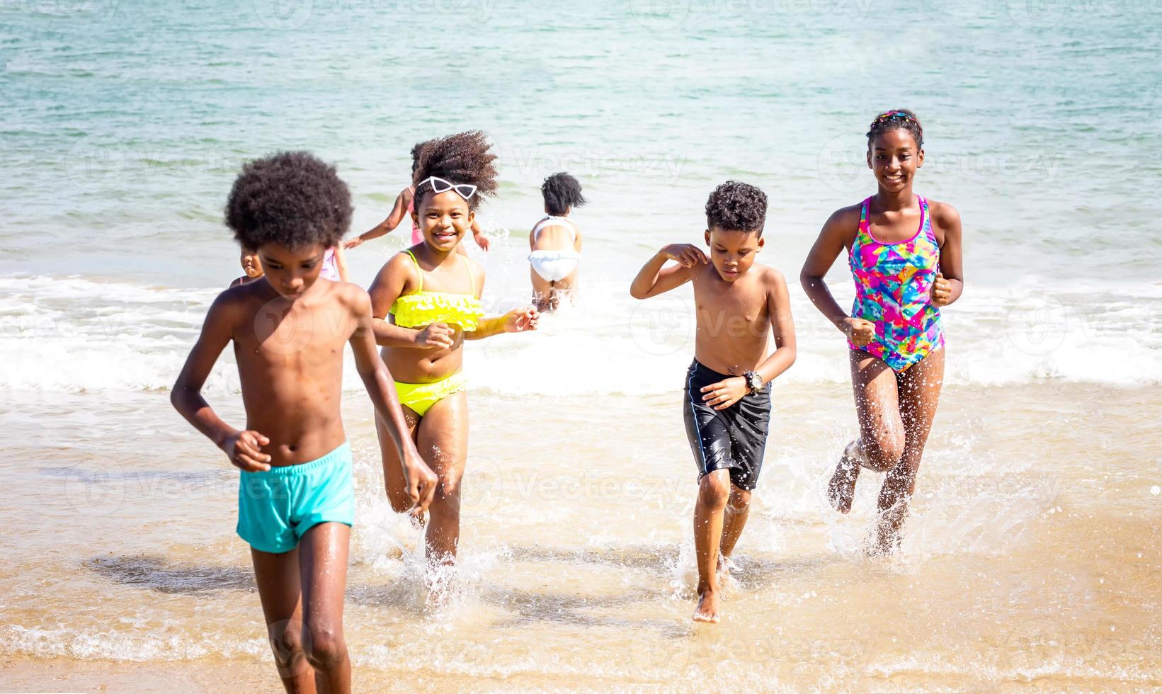 enfants jouant à courir sur le sable à la plage photo