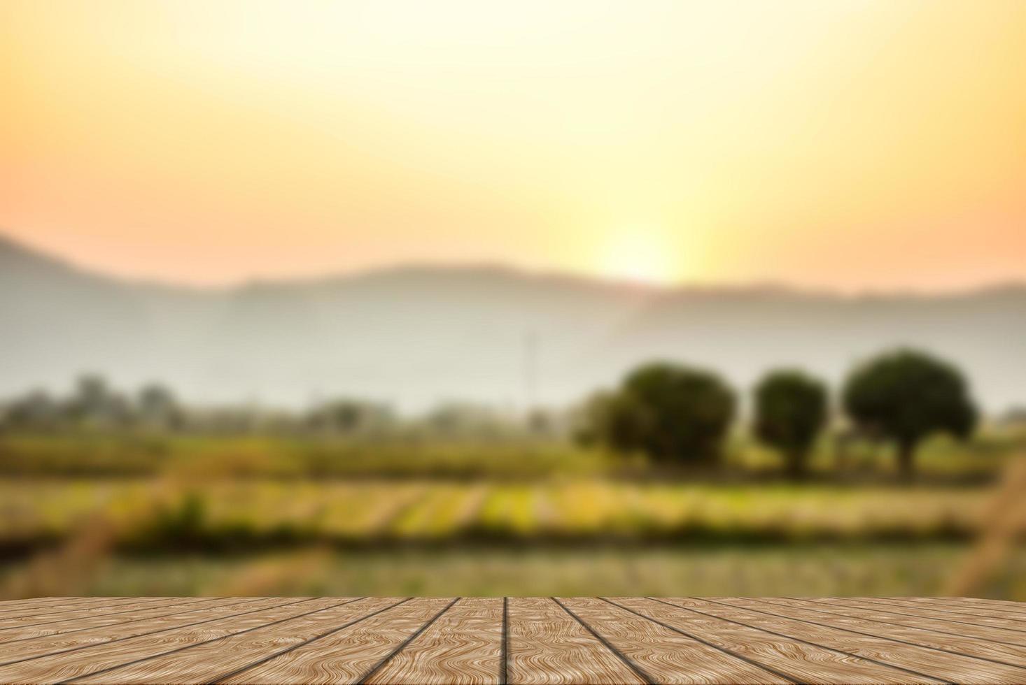 table en bois et flou de beauté, ciel coucher de soleil et montagnes en arrière-plan. photo