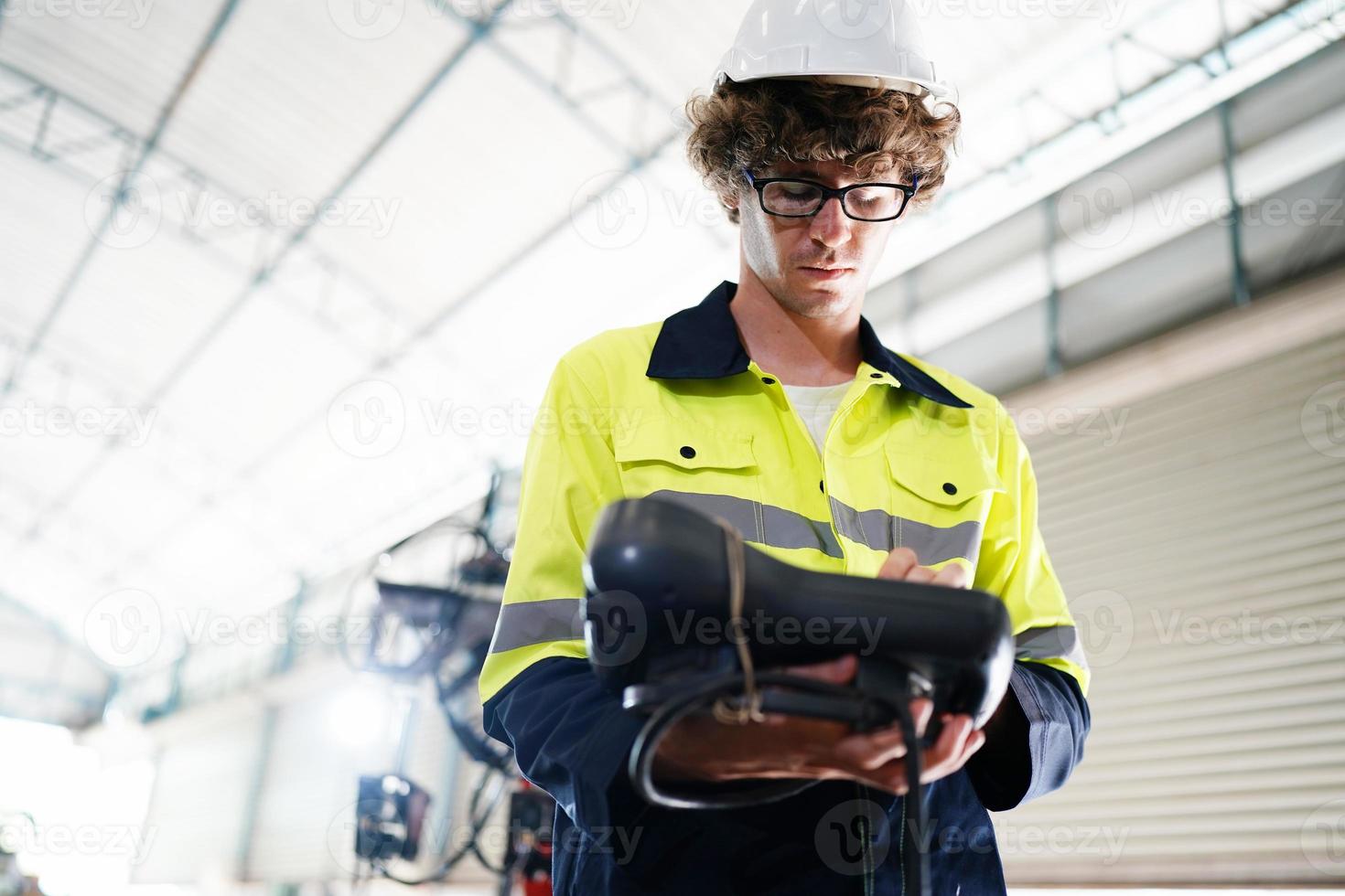 employé professionnel d'usine industrielle travaillant avec des pièces de machine, vérifiant et testant des équipements industriels et des bras de robot dans une grande usine de fabrication de fils et de câbles électroniques électriques photo