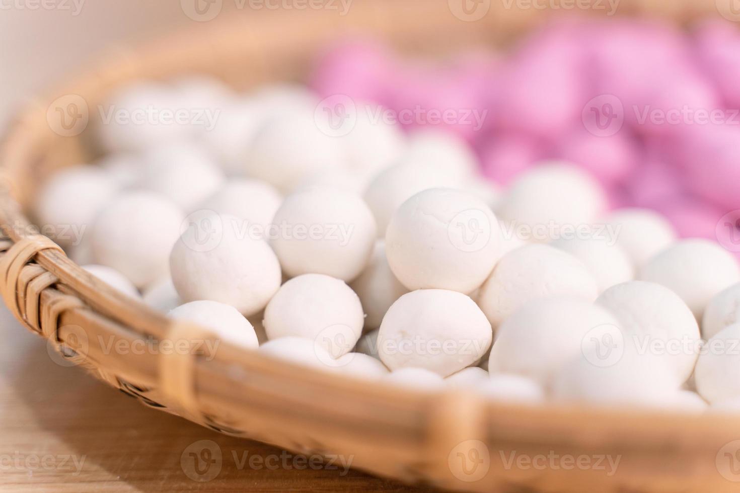 une femme asiatique fait du tang yuan, du yuan xiao, des boulettes de riz traditionnelles chinoises en rouge et blanc pour le nouvel an lunaire, festival d'hiver, gros plan. photo