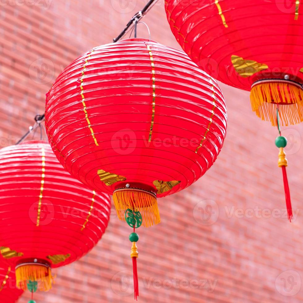 belle lanterne rouge ronde accrochée à la vieille rue traditionnelle, concept du festival du nouvel an lunaire chinois, gros plan. le mot sous-jacent signifie bénédiction. photo