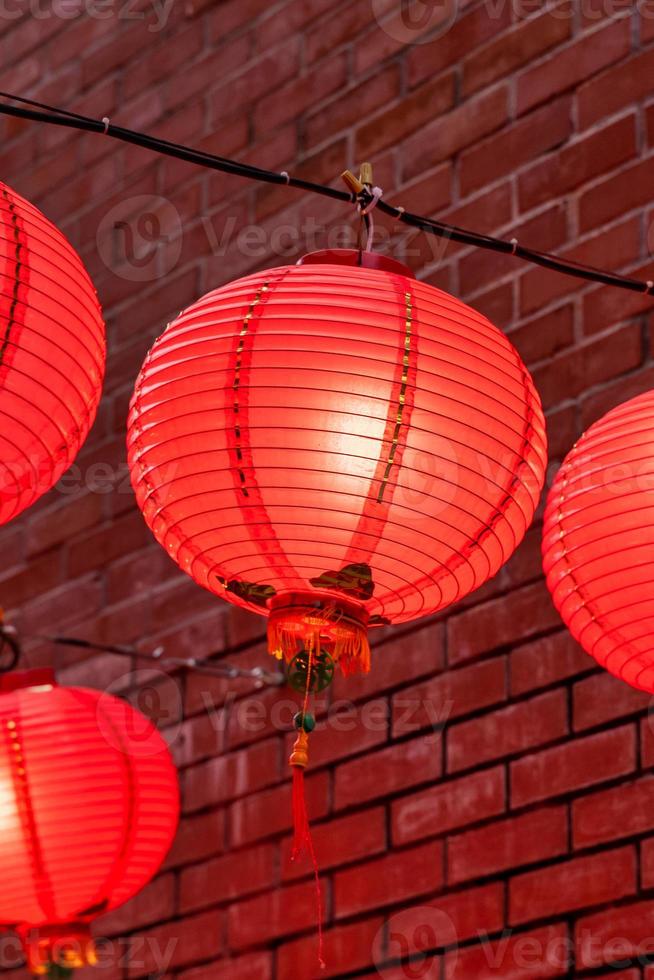 belle lanterne rouge ronde accrochée à la vieille rue traditionnelle, concept du festival du nouvel an lunaire chinois, gros plan. le mot sous-jacent signifie bénédiction. photo