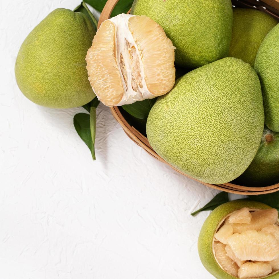 pomelo pelé frais, pomelo, pamplemousse, pamplemousse sur fond de bois clair. fruits de saison d'automne, vue de dessus, mise à plat, prise de vue sur table. photo