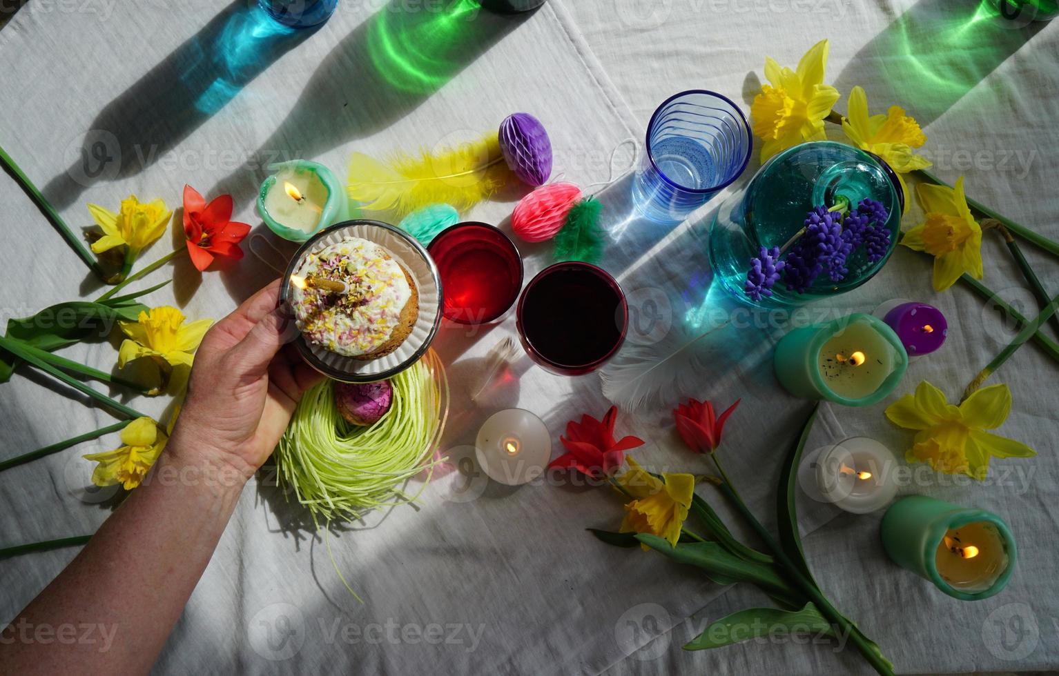 main de femme avec la pâtisserie à la levure pour pâques. ensemble de table de fête. photo