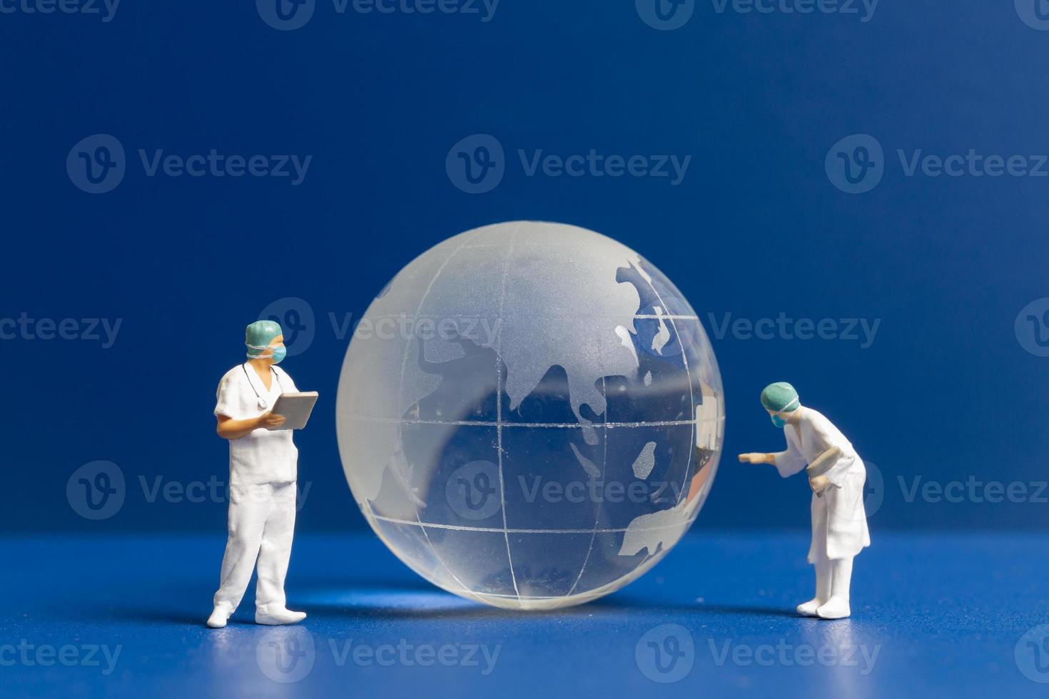 personnes miniatures médecin et infirmière vérifiant les soins de santé mondiaux photo